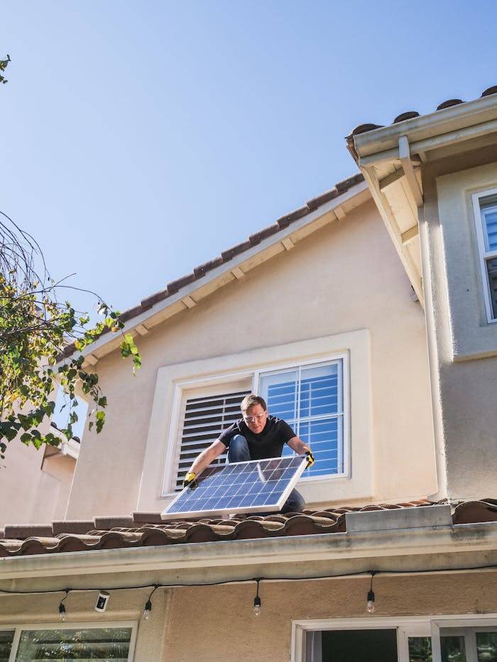 man installing solar panels on his roof